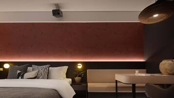 Una habitación de hotel moderna con cama, mesita de noche y un pequeño rincón de descanso.