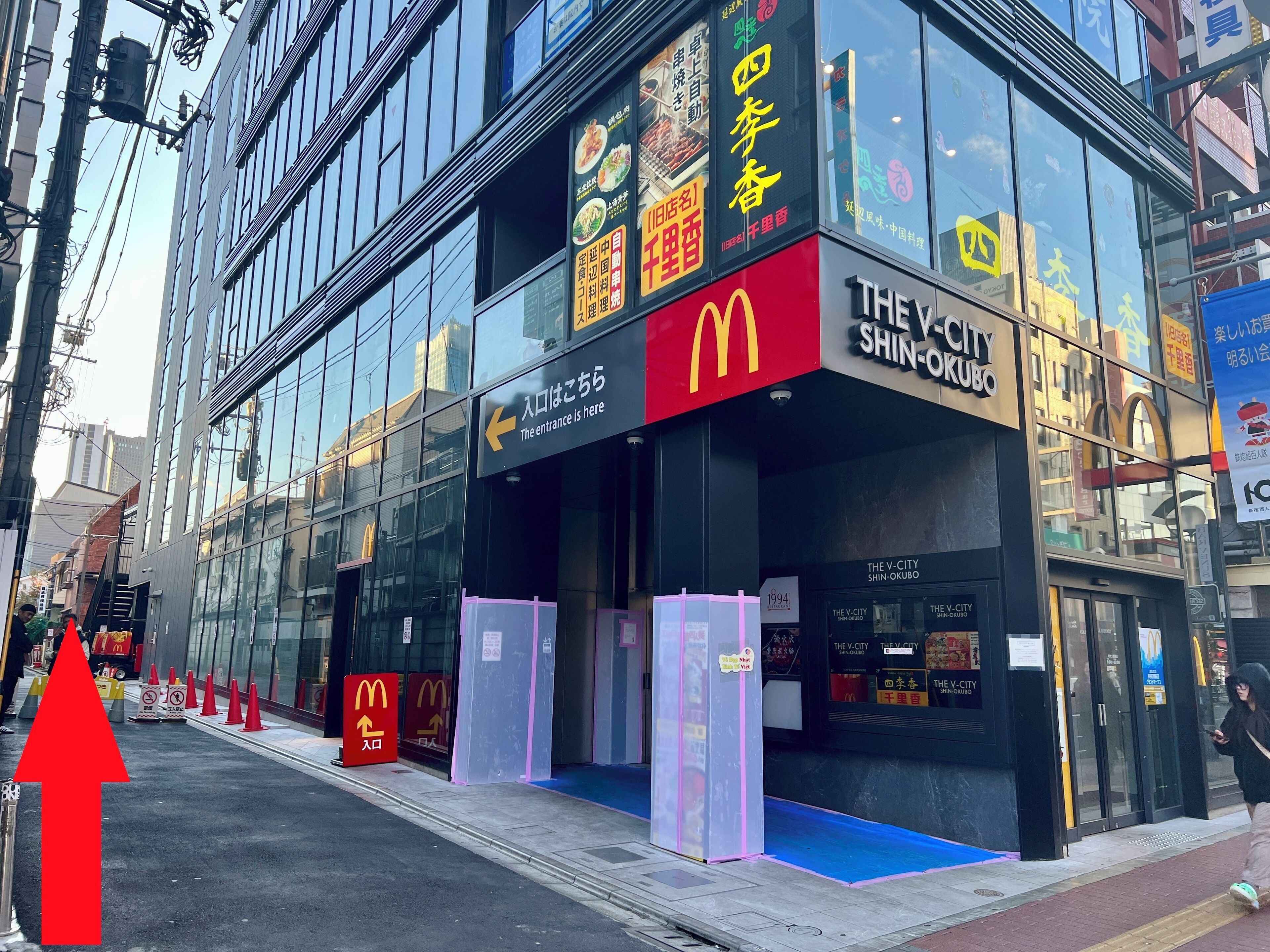 A McDonald's restaurant with glass fronts and signage in multiple languages.