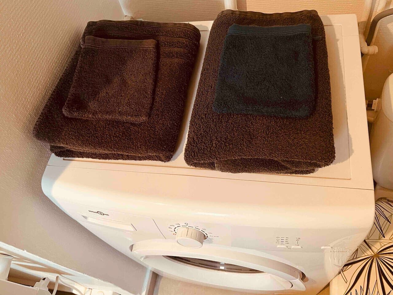 A washing machine with two towels on top.