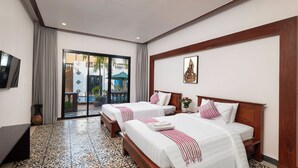 Une chambre d’hôtel avec deux lits, une télévision et une vue sur l’extérieur.