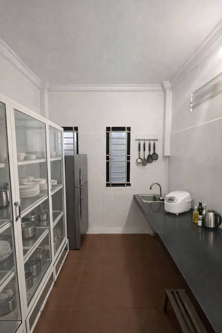 A compact kitchen with white cabinets, a refrigerator, a window, and a countertop with a sink and a toaster.