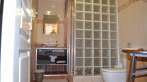 Un baño con lavabo, espejo y ducha.