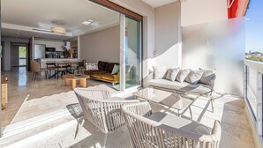 En moderne stue med balkon, et køkken og et spiseområde.