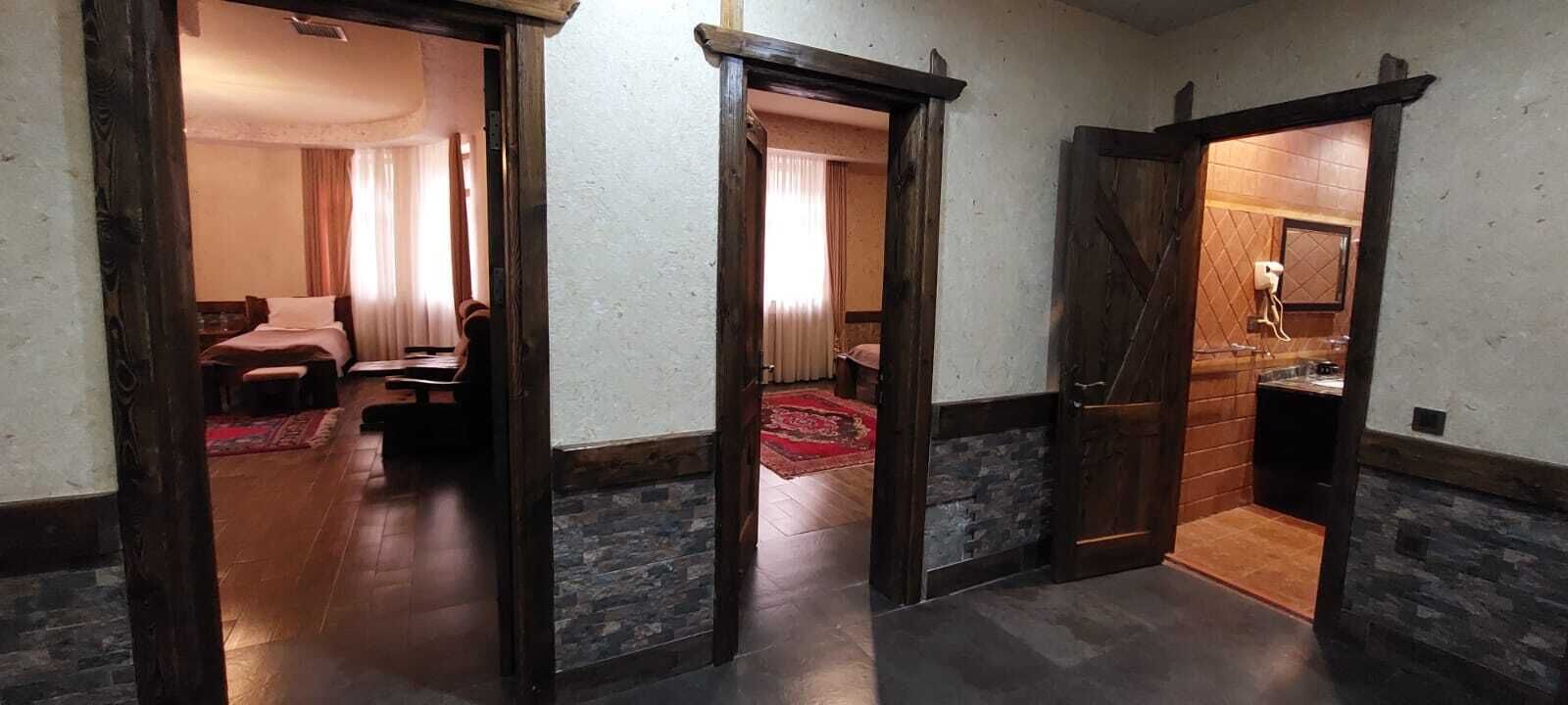 Un couloir d’hôtel avec des portes en bois donnant accès aux chambres.