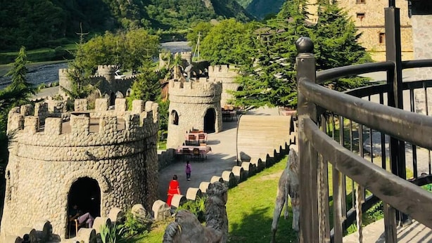 A castle with stone walls and towers, surrounded by lush green hills and a clear sky. - Senger Qala Riverside (Ilisu)