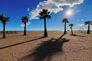 A beach with palm trees and a swing set. - 🌴 Cozy Vacation Home - Sunny & Ideally Located! ☀️🏖️ (Valras-Plage)