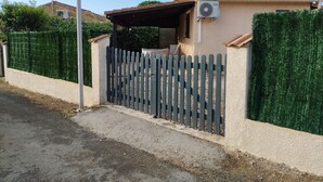 A gated residential property with a satellite dish, an air conditioning unit, and a covered patio area. - 🌴 Cocooning Holiday Home - Sunny & Ideally Placed! ☀️🏖️ (Valras-Plage)