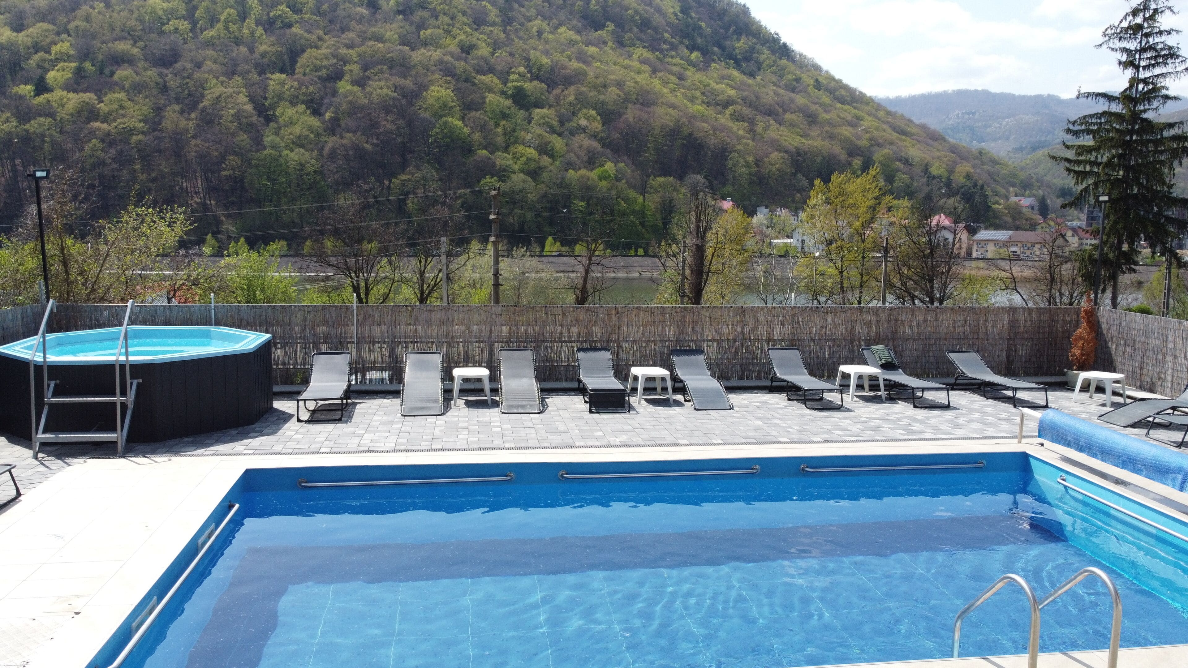 Una piscina al aire libre de temporada, sillones reclinables de piscina