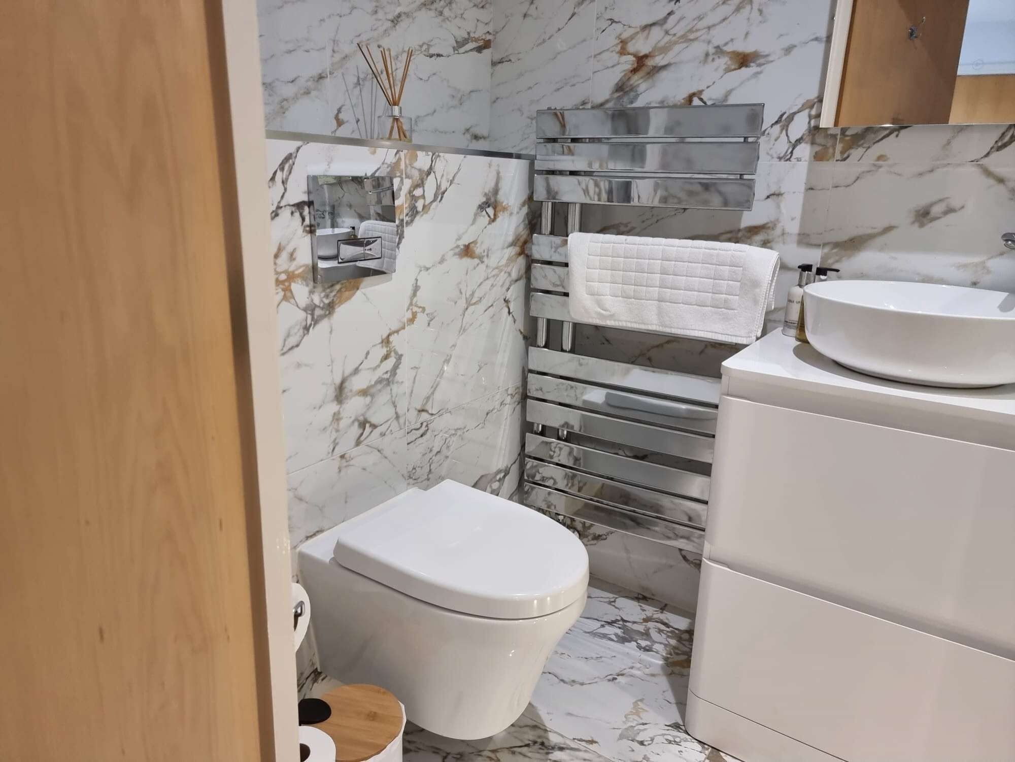 A bathroom with a toilet, a sink, and a towel rack.