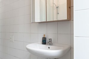 Eenvoudig appartement | Badkamer | Een douche, gratis toiletartikelen, een haardroger, handdoeken