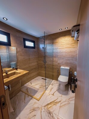 A modern bathroom with a glass-enclosed shower, a marble-tiled floor, a wooden vanity, and a toilet. - Hotel Atlas Day (Agoudi N'Lkhair)