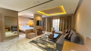 A modern hotel room with a bed, sofa, and a TV. - Hotel Atlas Day (Agoudi N'Lkhair)