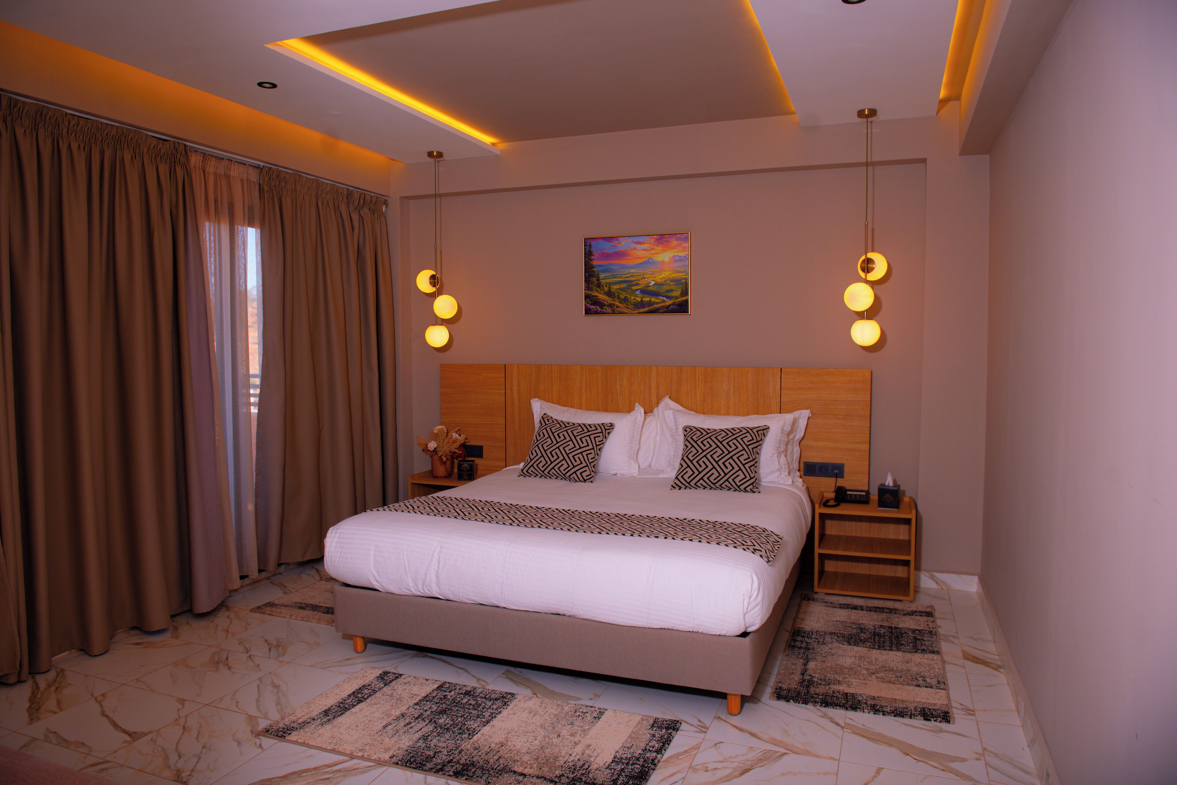 A hotel room with a large bed, a nightstand, a lamp, and a painting on the wall.
