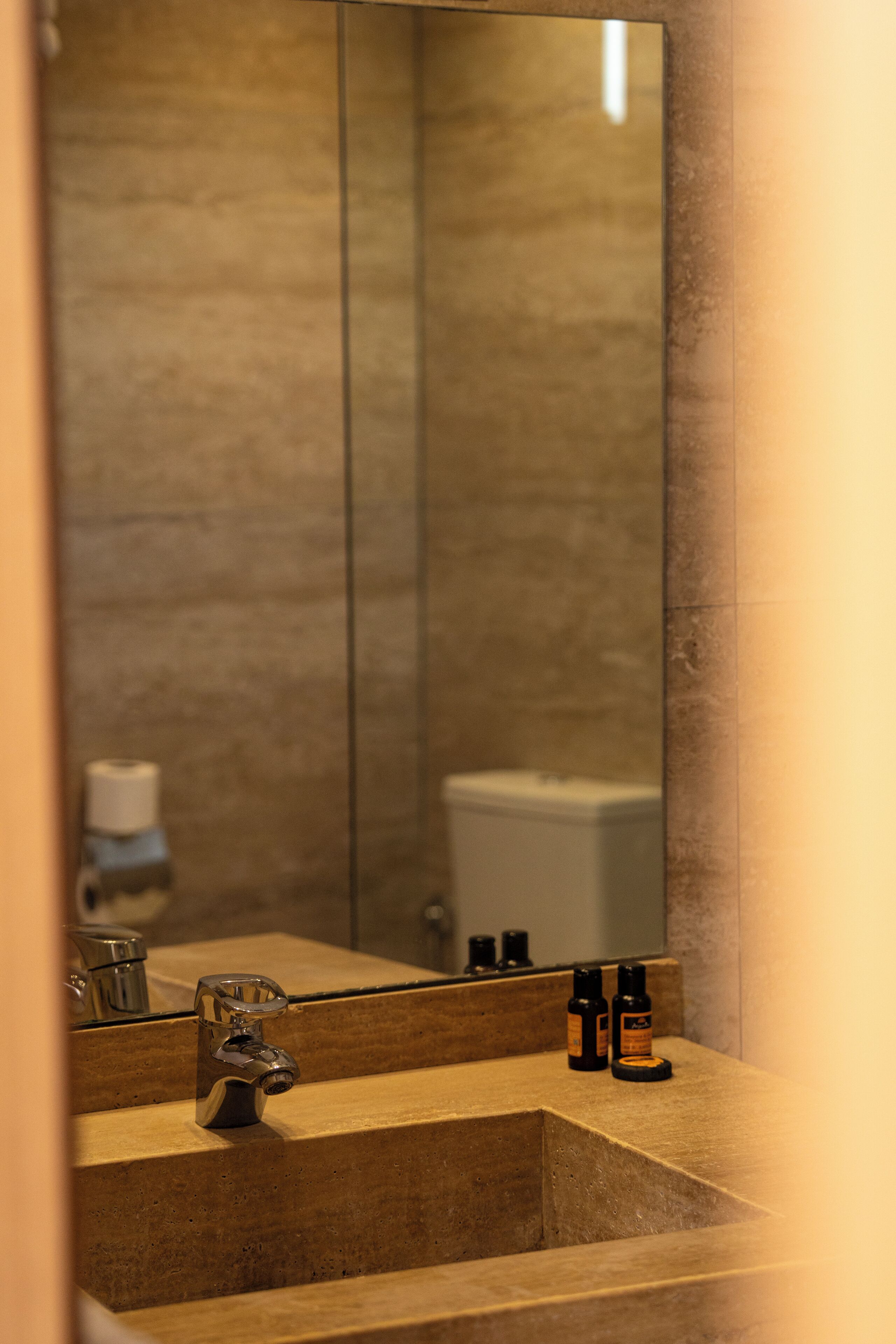 Ein Badezimmer mit Waschbecken, Spiegel und Toiletteartikeln.