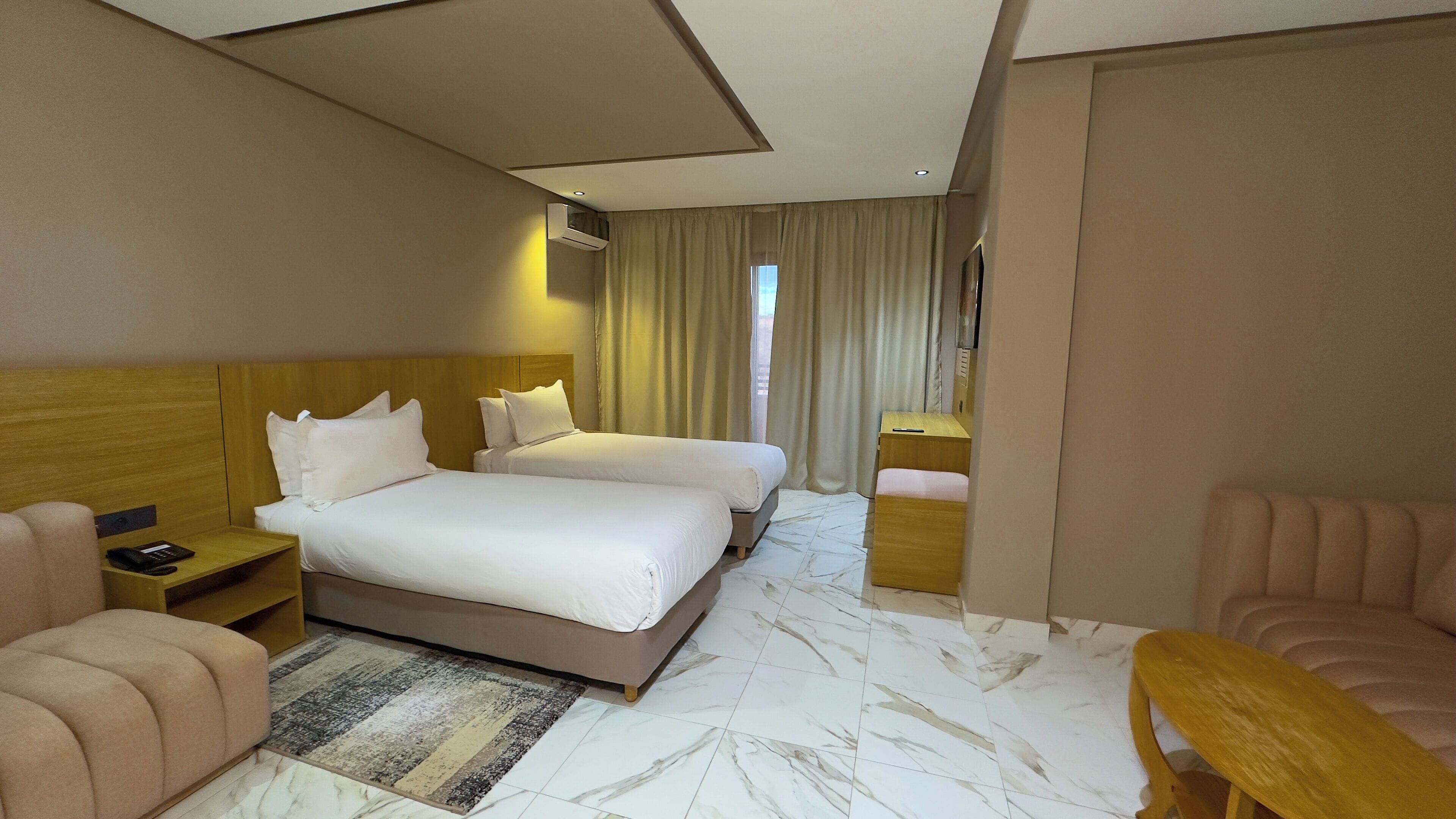 Una habitación de hotel con dos camas, un sofá, un escritorio y una silla.