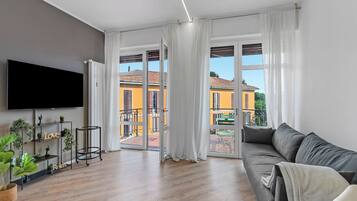 Familie appartement, meerdere slaapkamers (Specchio Di Cielo Arona Center) | Woonruimte | Een 21-inch flatscreentelevisie met kabelzenders