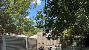 A grassy outdoor area with wooden barrels and white stools arranged in a row. - Yarck hotel  (Yarck)
