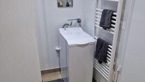 Een kleine badkamer met een witte wastafel, een handdoekhouder en een toilet.