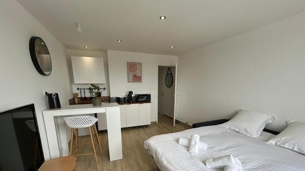Een moderne hotelkamer met een bed, een bureau, een stoel en een televisie.