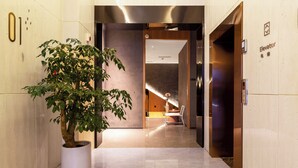 A modern elevator with a digital display, a potted plant, and a clean, minimalist interior. - TRUE Go hotel (Chengdu)