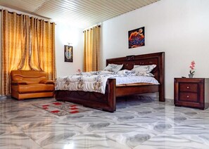 Un dormitorio con una cama de madera, un sofá de cuero y una mesita de noche.