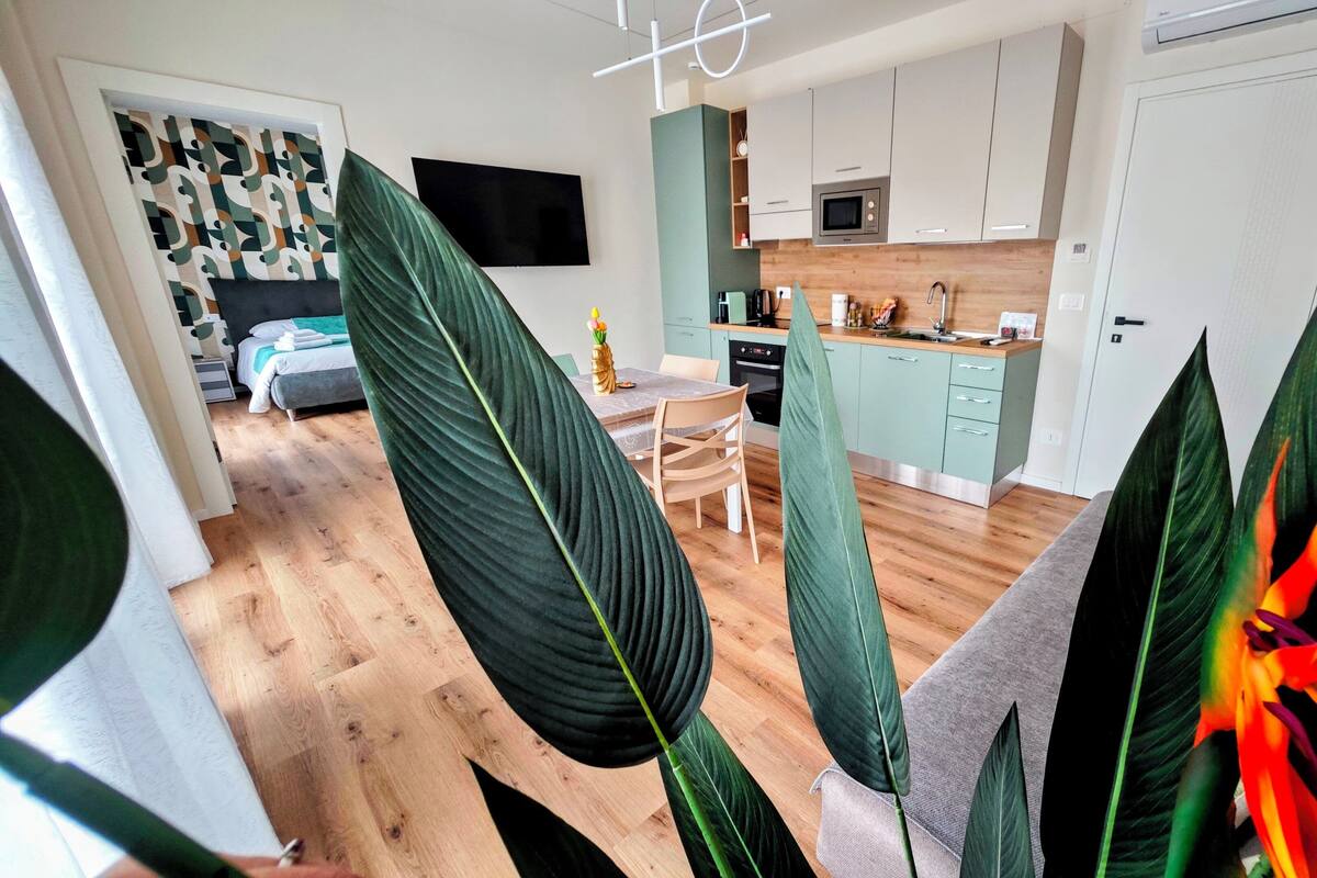 A modern kitchen with a flat-screen TV, a microwave, and a sink.