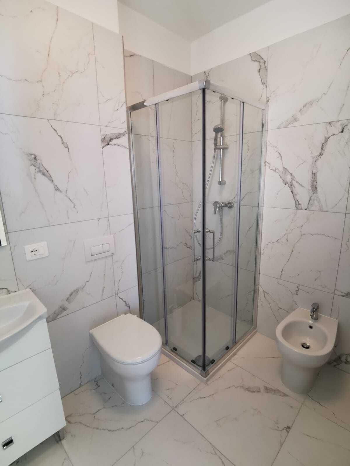 Ein Badezimmer mit einer Duschkabine, einer Toilette und einem Bidet.