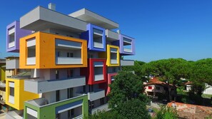 A multi-story building with a unique architectural design featuring various colored sections. - Bright Studio Close to the sea (San Michele al Tagliamento)