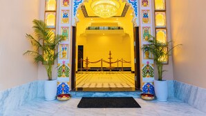 A grand entrance with a chandelier, decorative panels, and a tiled floor. - Aryavarta A boutique abode (Udaipur)