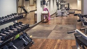 Un gimnàs amb equip d'exercici, un mirall i una cinta de córrer.
