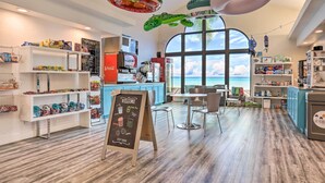A cafe with a self-serve station, seating area, and a view of the ocean. - Resort Perks & Family Fun! St George Retreat (St. George)
