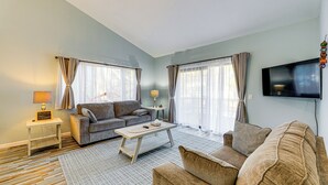 Ein Wohnzimmer mit Sofa, Couchtisch und Fernseher.