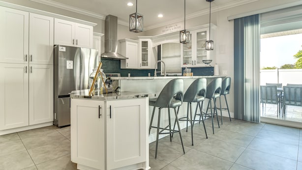 A modern kitchen with white cabinetry, stainless steel appliances, and a bar area with stools. - Pool Heat Included! Seminole Getaway w/ Game Room (Seminole)