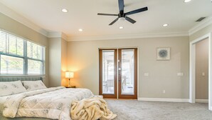 A bedroom with a bed, a ceiling fan, a door with a view, and a window with blinds. - Pool Heat Included! Seminole Getaway w/ Game Room (Seminole)