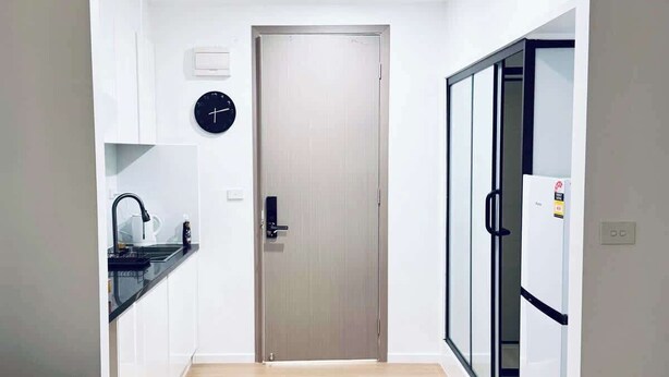 A modern kitchen with white cabinets, a black countertop, and a stainless steel sink. - Metawise Peaceful Home Close to Monash Uni and Chadstone U2 (Melbourne)