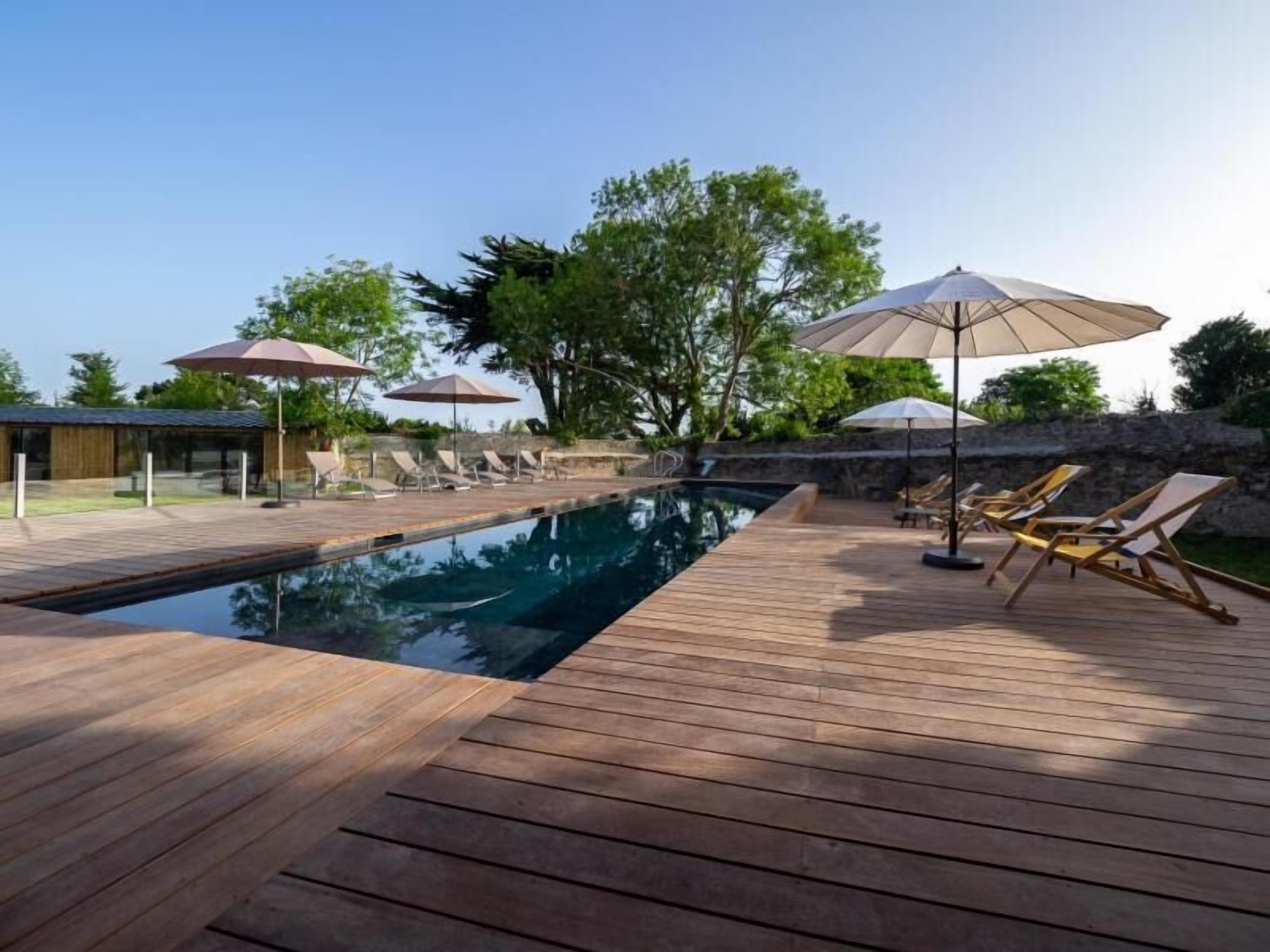 Alberca al aire libre, sombrillas en la alberca y camastros 