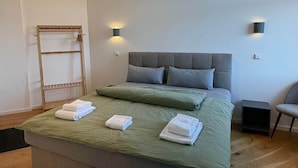 A modern bedroom with a large bed, two bedside tables, and a built-in bench. - Apartment No.07 with one bedroom (Badenweiler)