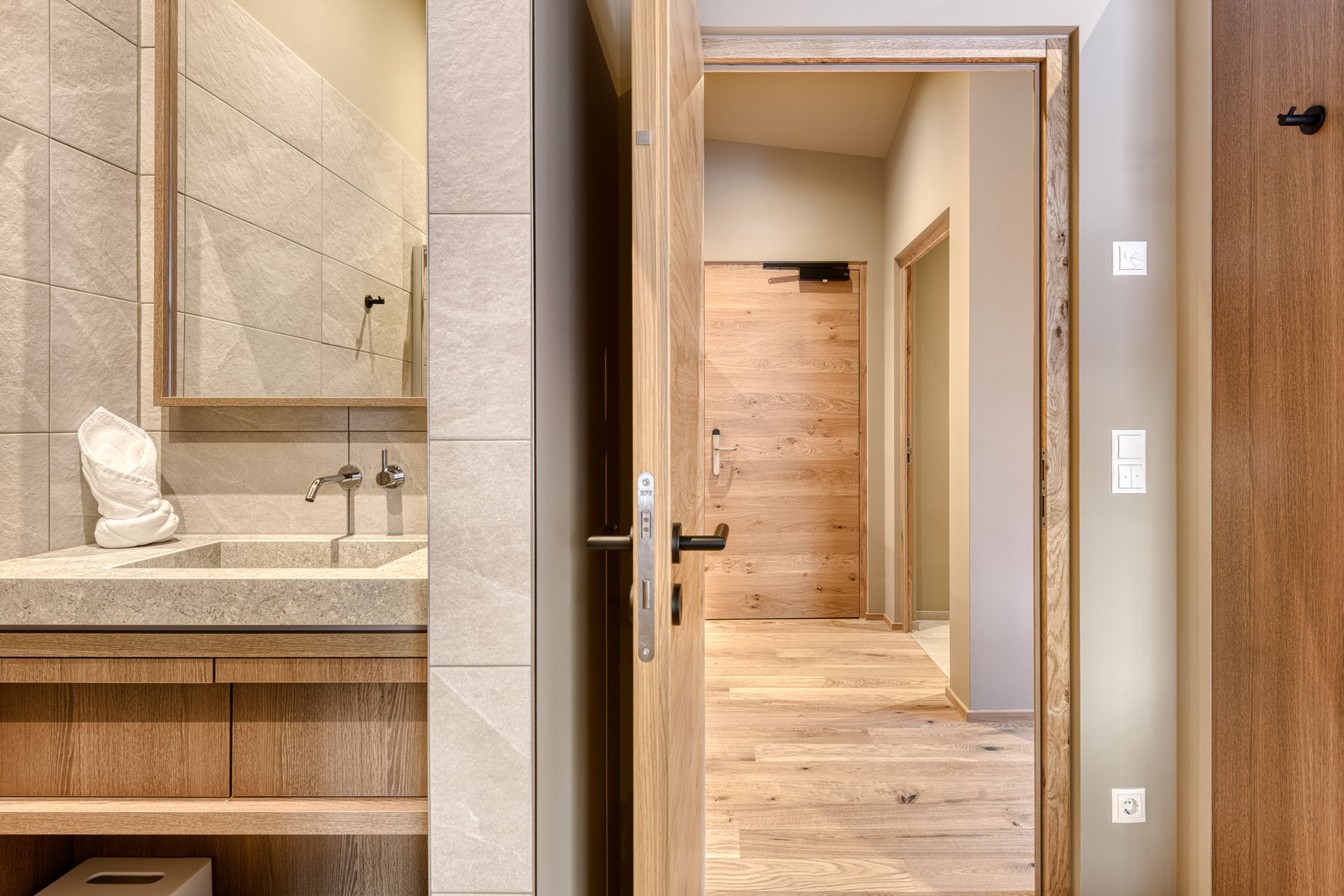 A bathroom with a large mirror, a sink, and a towel.