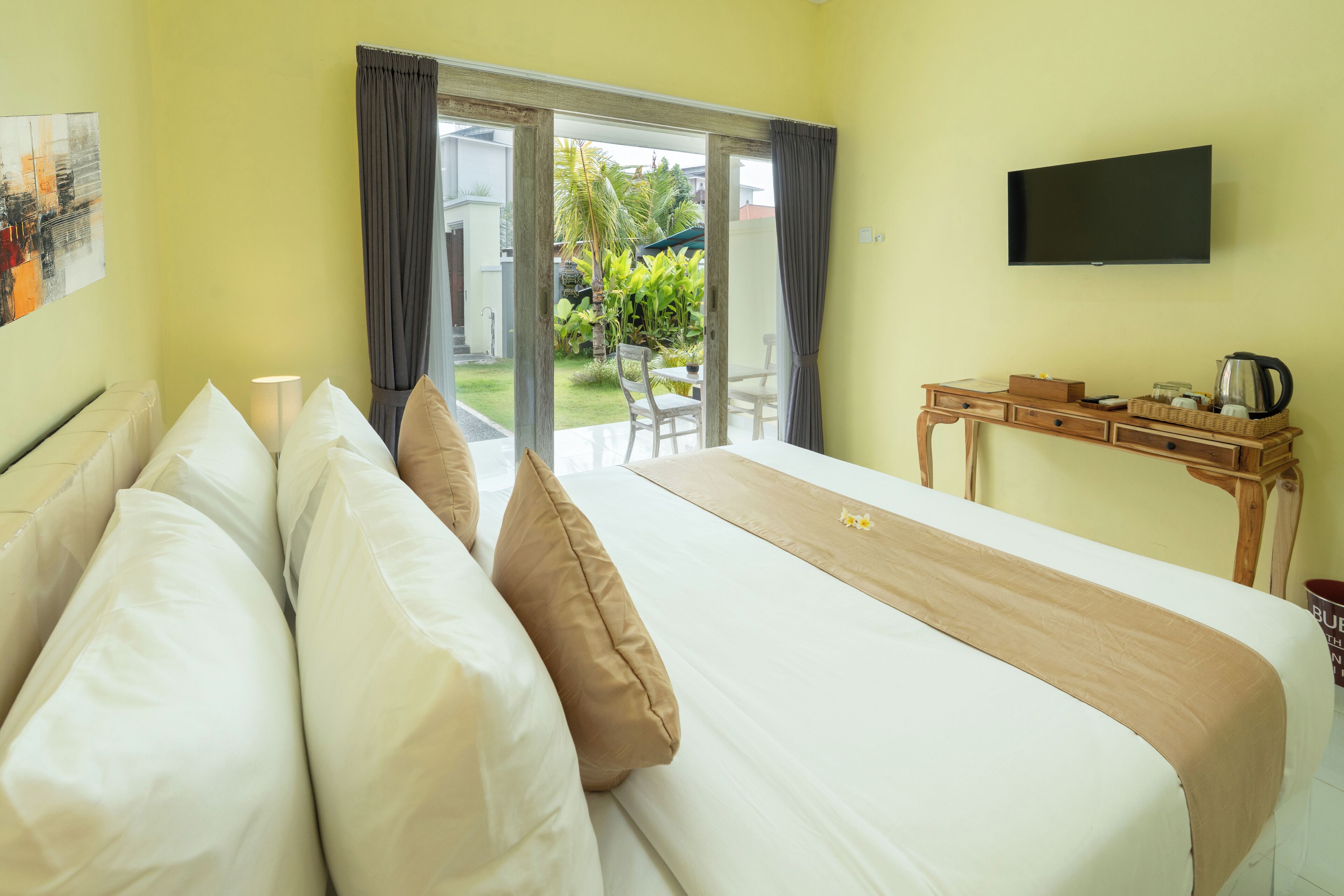 A hotel room with a bed, a desk, and a TV.