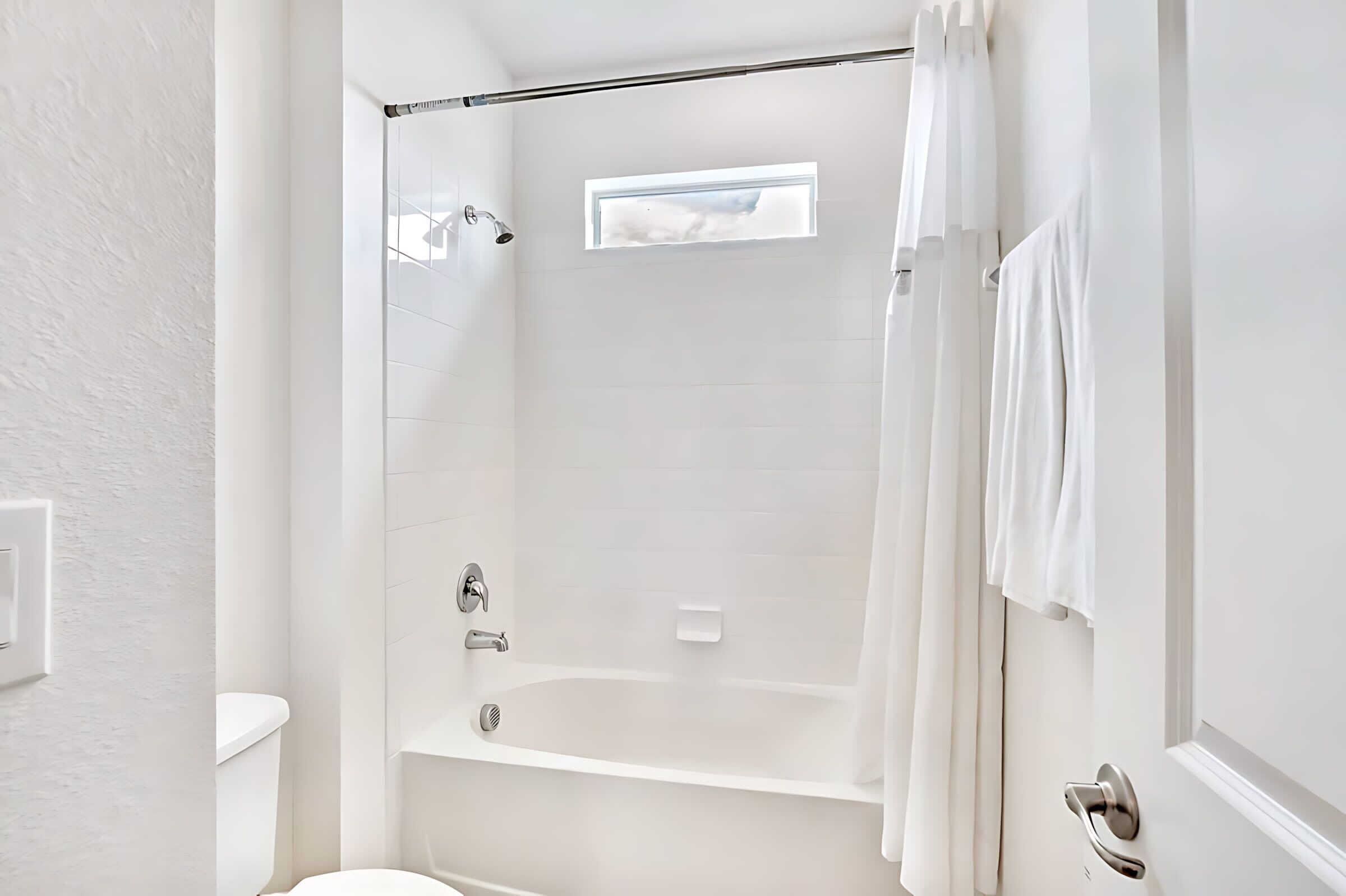 Een moderne badkamer met een inloopdouche, een badkuip en een toilet.
