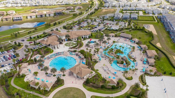 Vue aérienne d’un complexe hôtelier doté de plusieurs piscines, d’une grande piscine centrale et d’une zone de plage.
