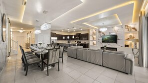 A modern kitchen with dark cabinets, a central island, and a built-in oven. - Exquisite 10br Luxury Villa Pool Hot Tub Arcade (Davenport)