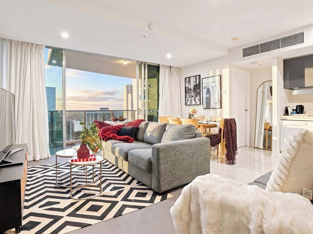 Un salon moderne avec un canapé, une table basse et une vue sur la ville.