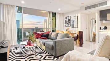 Un salon moderne avec un canapé, une table basse et une vue sur la ville.