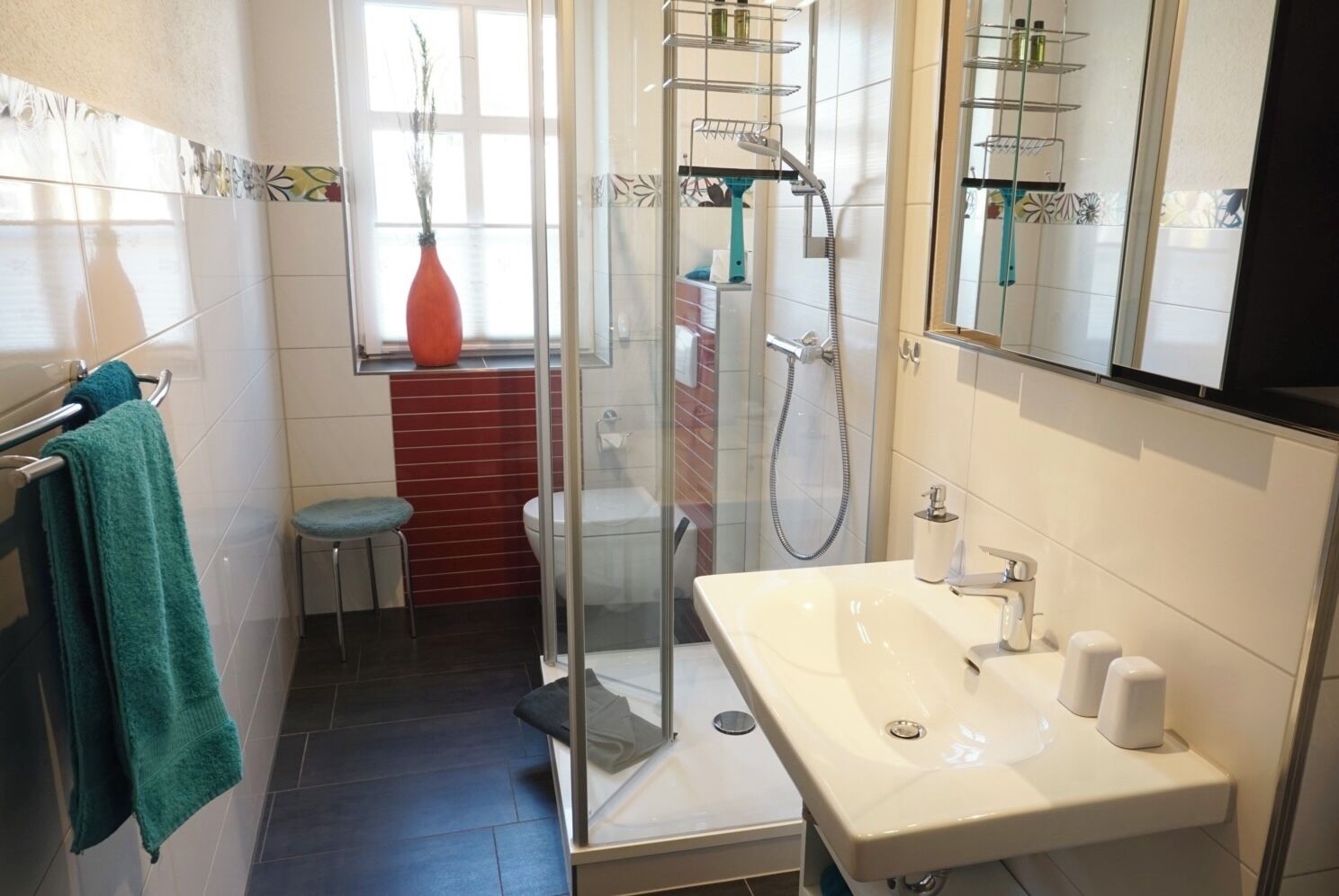 A compact bathroom with a shower, toilet, and sink.