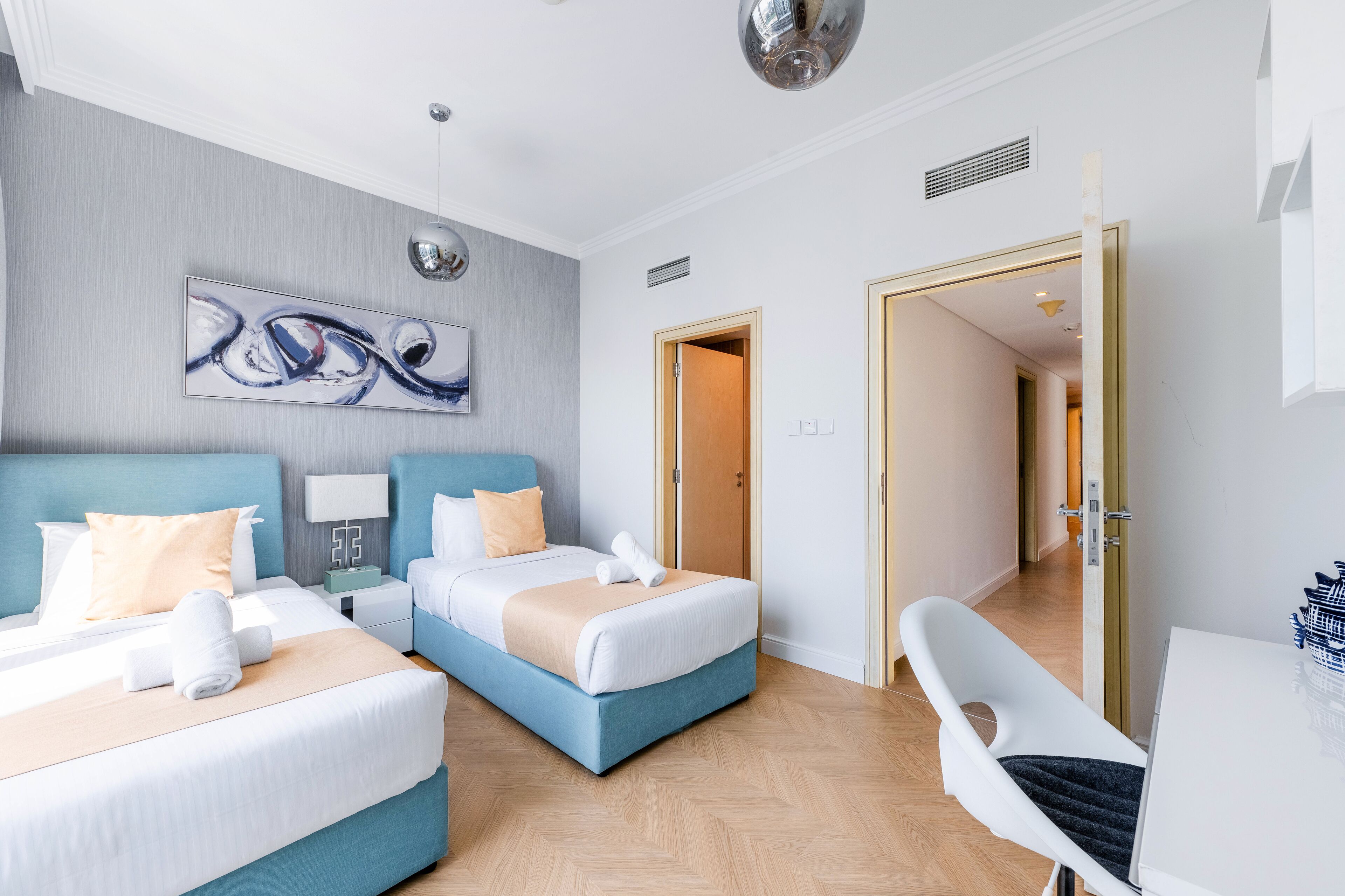 Ein Hotelzimmer mit zwei Betten, einem Schreibtisch und einem Stuhl.