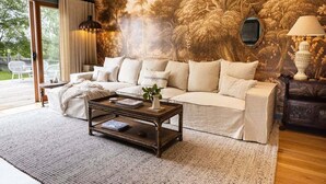 Ein Wohnzimmer mit einer großen Wandmalerei, einem Sofa, einem Couchtisch und einer Lampe.