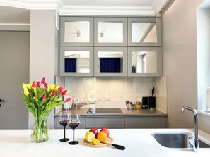 A modern kitchen with grey cabinets, a marble backsplash, and a white countertop. - BP Gray Premium (Toruń)