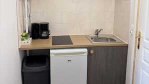 A compact kitchenette with a built-in dishwasher, a sink, and a coffee maker.
