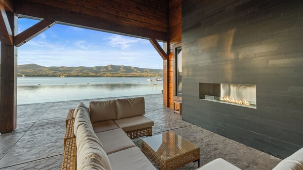 A wooden ceiling, a stone floor, a sofa, a glass table, and a fireplace. - LAKEFRONT - 5 STAR 4,500 sqft! Hot Tub, Fire Pit, Dock, Fireworks & Fireworks (Big Bear Lake)